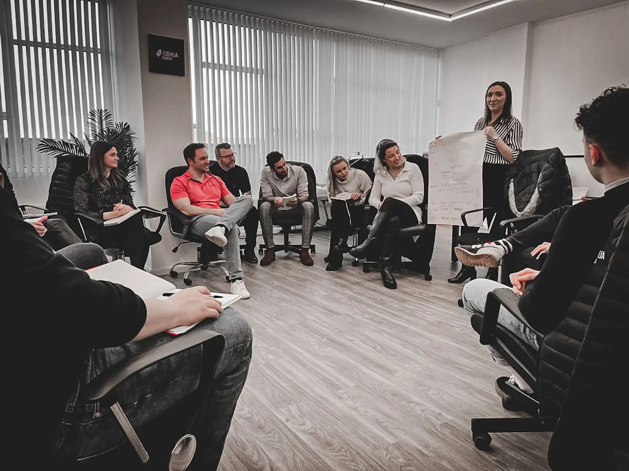 Dr Lewis Haydon (red shirt) running a leadership team session with a client team